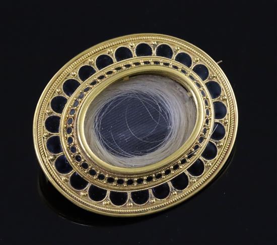 A Victorian gold and black enamel oval mourning brooch, 40mm.